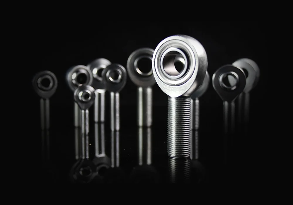heim joints demonstration SYZ Rod Ends Multiple heim joints displayed in various sizes on a reflective black surface