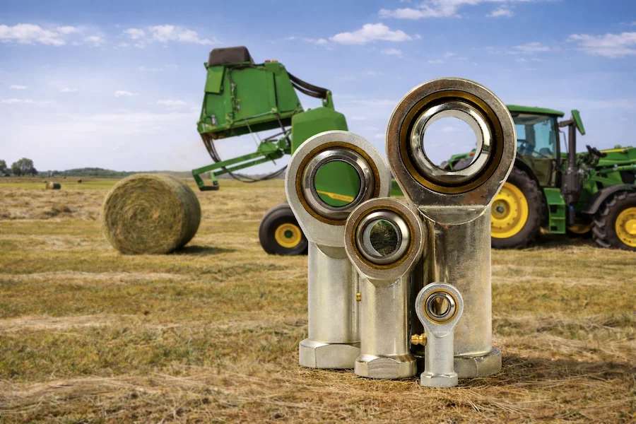 Carbon steel rod ends in agricultural baler linkage